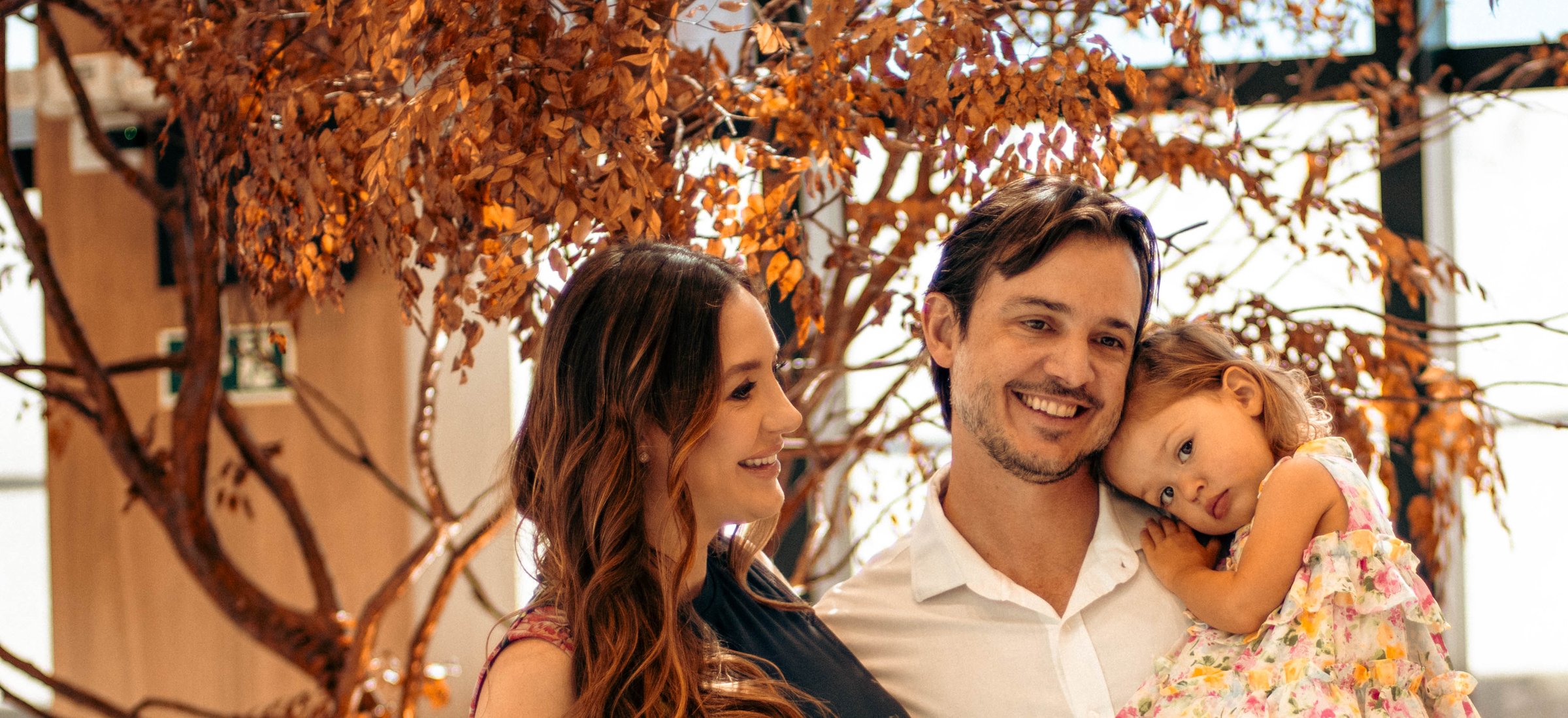 Casal com a filha no colo, a mãe grávida, no saguão do Saine Health Complex